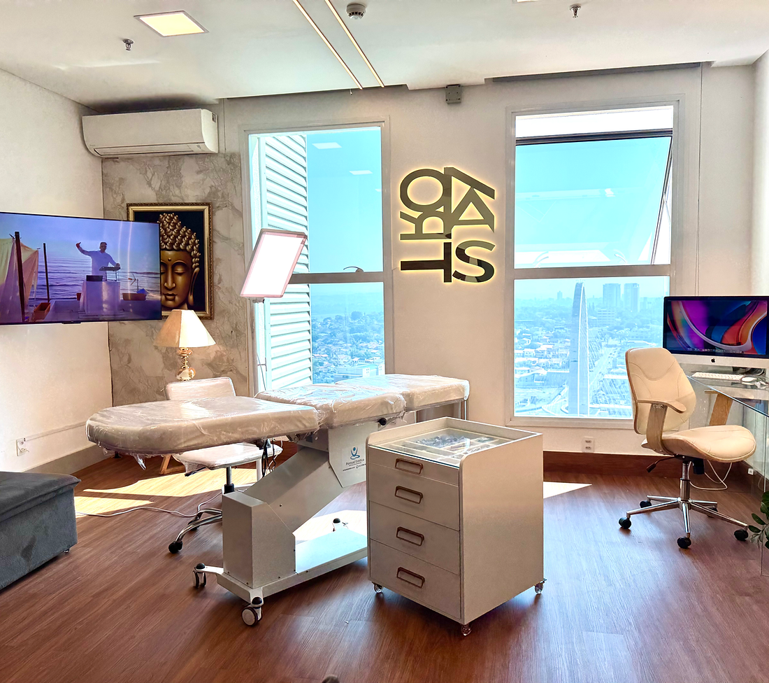 Interior do estúdio Ks Kastro Tattoo com logo iluminada e vista da cidade